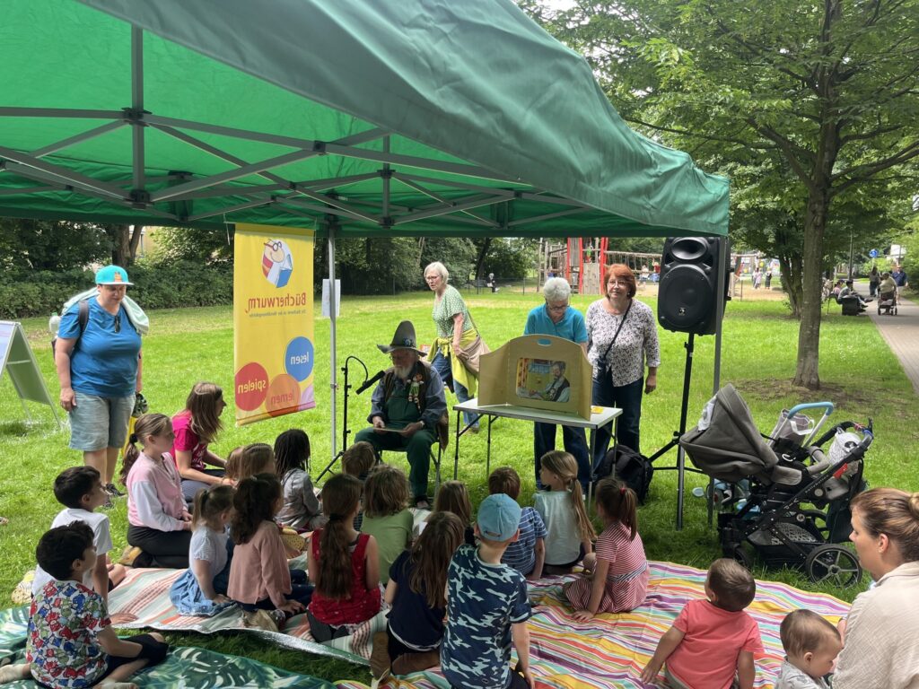 „Eselsohr“ on Tourt: Es war ein sehr schöner Nachmittag mit Pettersson und Findus am Holweider Markt oder genauer gesagt: auf der Wiese. Hier lauschten die Kinder gespannt der Geschichte, wie Findus das Sprechen lernte. Organisiert hatte die wunderbare Vorlese- und Bastel-Aktion Lis Nørgaard vom Fachausschuss "Eselsohr" und dem "Runden Tisch Holweide".
